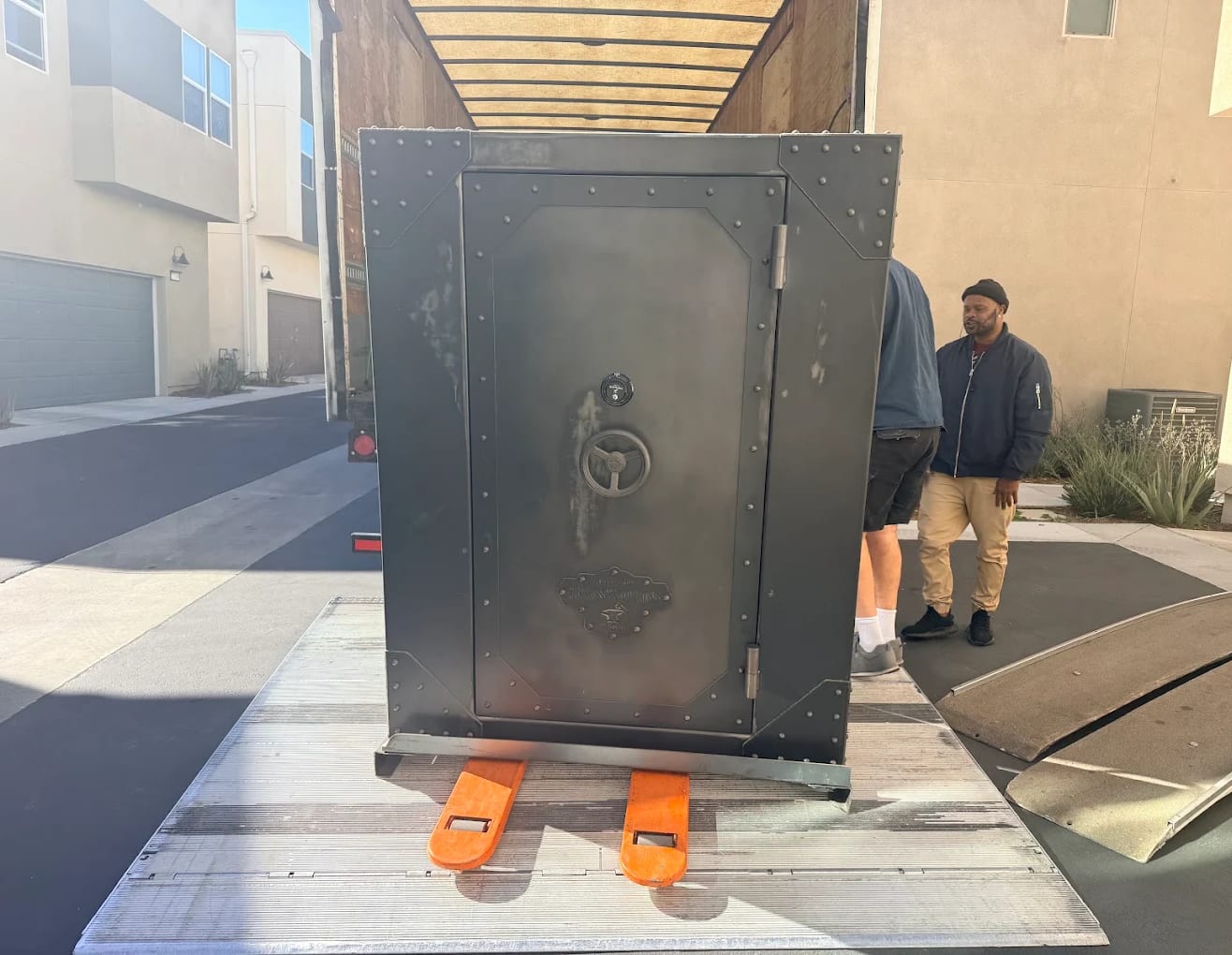 A large steel gun safe strapped upright on the BEST MOVE truck liftgate