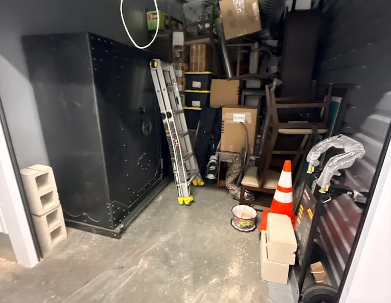 A storage unit loaded by BEST MOVE, contents stacked tight to the walls with a walkway left clear
